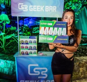 Mujer sosteniendo un muestrario de geek bar en un evento de latam vaping en panamá