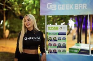 mujer con remera de geek bar junto a stand de geek bar